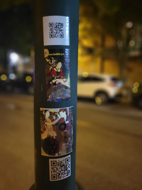 Street pole adorned with a QR code and a series of vibrant art stickers featuring Japanese themes and the web address www.Ox888.art